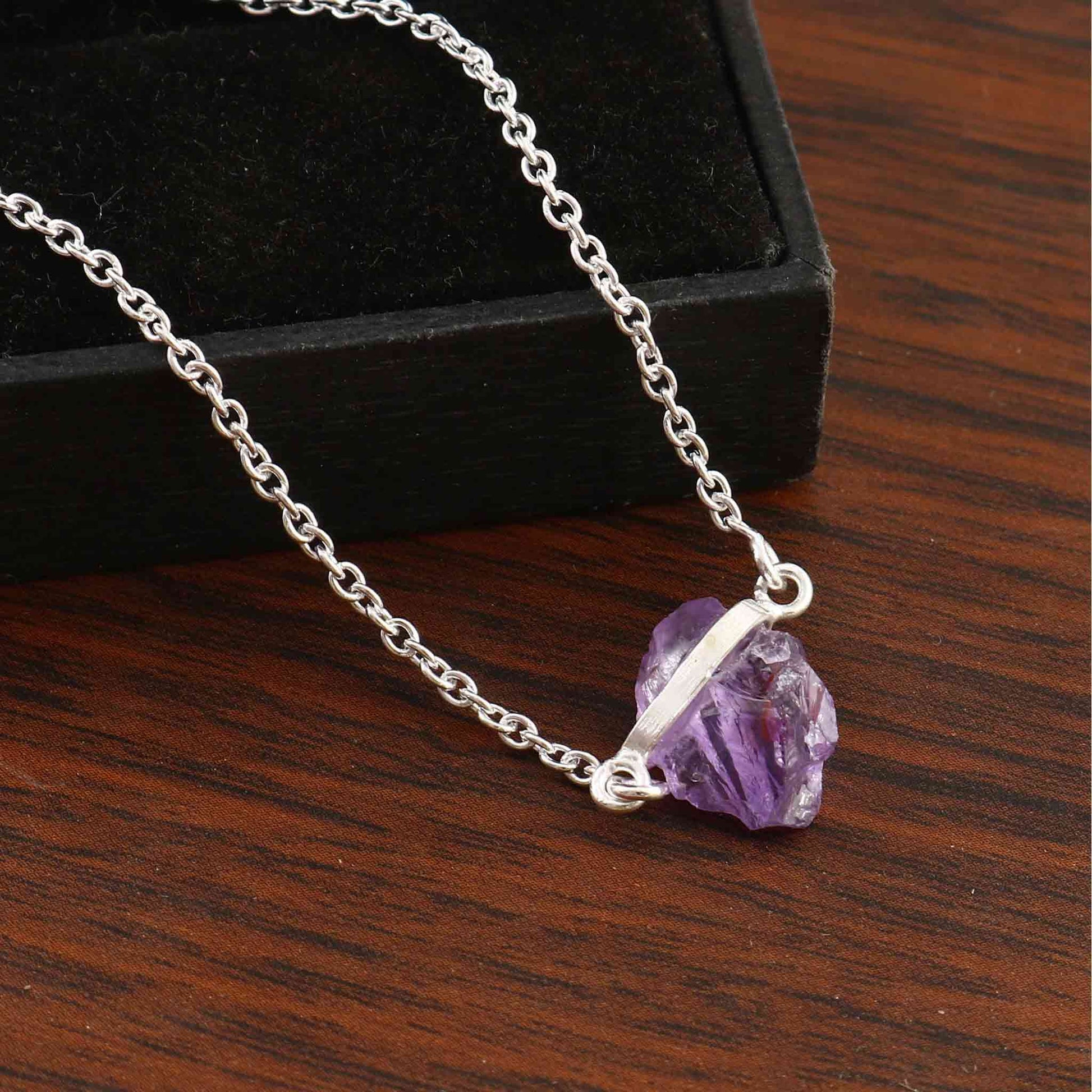 Elegant raw Amethyst crystal necklace with sterling silver chain, featuring natural, unique stones in a free-form shape.